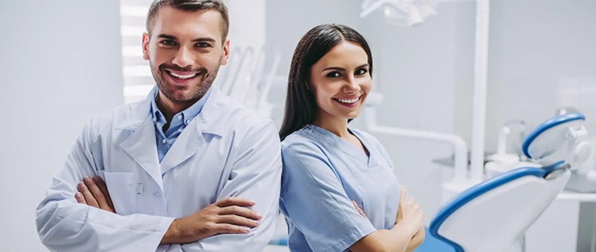 Smiling dentist and dental assistant in a treatment room